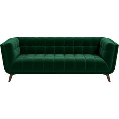 a green velvet couch with wooden legs