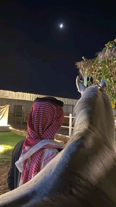 a man riding on the back of a horse at night