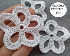 three crochet flower appliques are shown in the palm of someone's hand