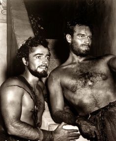 two men standing next to each other in a bathroom