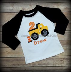 a white and black shirt with a yellow truck on it that says 2nd grade drew