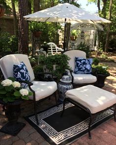 an outdoor patio with chairs, table and umbrella