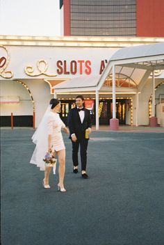 a bride and groom walking in front of a casino