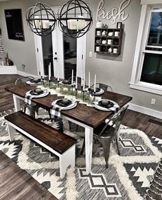 a dining room table with two benches in front of it and an area rug on the floor