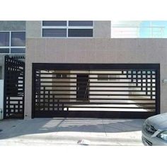 a car parked in front of a building with a gate on the side of it