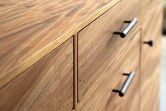 an image of a wooden dresser with metal handles