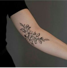 a black and white flower tattoo on the arm