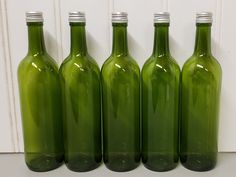 four green glass bottles lined up in a row