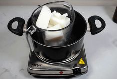 there is a pot with some food in it on the stove top and ice cubes inside