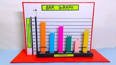 a bar graph is displayed on top of a red card holder with colored pencils in it