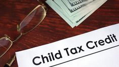 a child tax credit form on a desk with glasses and stacks of money next to it