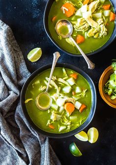 two bowls filled with soup and garnished with cilantro, celery, and carrots