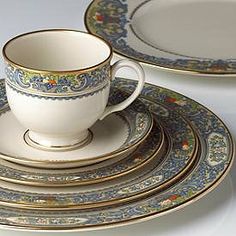 an image of a set of dinnerware with gold trimmings and blue flowers