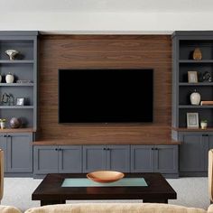 a living room filled with furniture and a flat screen tv mounted on a wall above a fireplace