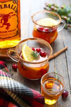 two glasses filled with liquid and garnished with cranberries