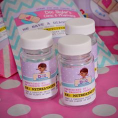 two bottles of baby powder sitting on top of a pink polka dot covered tablecloth