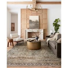 a living room filled with furniture and a fire place under a chandelier above a fireplace