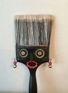 a close up of a paint brush with eyes on it's head and nose