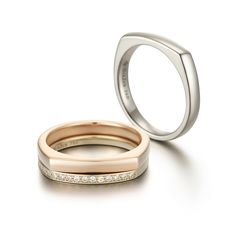 two wedding bands with diamonds on each side and one in the other's band