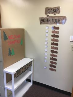 a welcome to camp sign is on the wall next to a cardboard board that says welcome to camp schedule