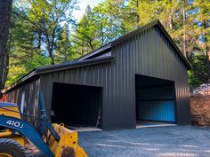 a tractor parked in front of a metal building with two garages on each side