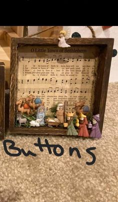 two small wooden frames with musical notes and figurines in them on the floor