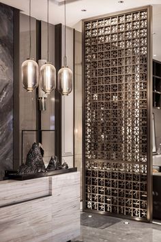 an elegant bathroom with marble counter tops and lights hanging from the ceiling, along with modern lighting fixtures