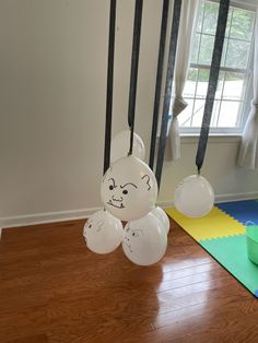 some balloons are hanging from the ceiling in a room with wood floors and white walls