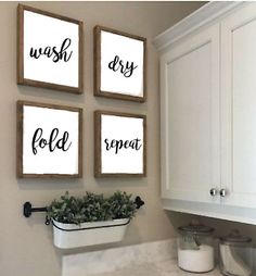 three framed art pieces hanging on the wall above a sink in a bathroom with white cabinets