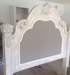 an ornate white bed frame with mirror on top