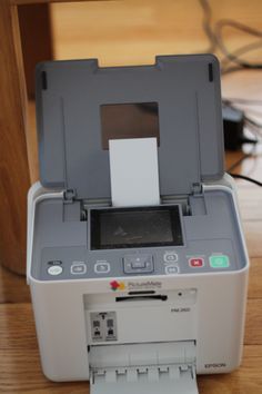 a printer sitting on top of a wooden table