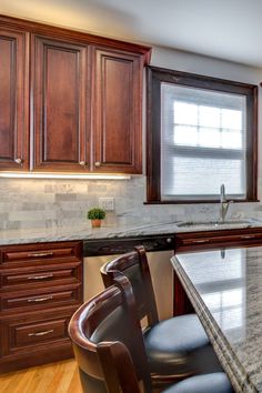 a kitchen with marble counter tops and wooden cabinets