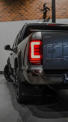 the back end of a pickup truck with its tail lights on in a showroom