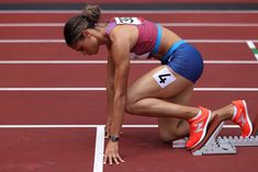 a woman kneeling down on top of a track