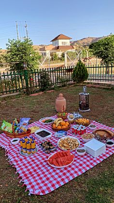 a picnic table with food on it in the grass