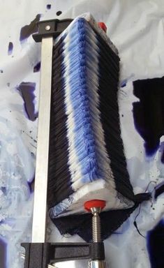 a blue and black brush sitting on top of a piece of metal