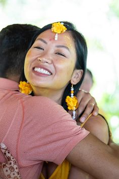 a woman with flowers in her hair hugging a man