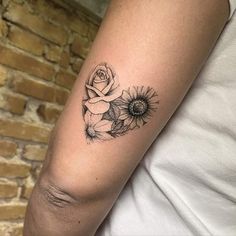 a black and white photo of a woman's arm with sunflowers on it