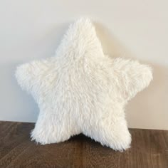 a white star pillow sitting on top of a wooden table