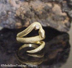 Designer 18k Yellow Gold Coiled Serpent Snake Diamond Bypass Wrap Ring Size 6 Medallion Trading Company   14K YELLOW GOLD  SNAKE RING WITH A DIAMOND- SIZE 6   Condition: Good vintage condition. Professionally cleaned and polished Weight: 5.74 grams Size: 6 Measurements: The ring is approximately .75 inches high (north to south) but it is flexible enough that it could be adjusted Markings: k18 Gemstones: (1) natural round cut diamon Antique Gold Snake-shaped Jewelry, Antique Snake-shaped Yellow Gold Jewelry, Antique 14k Gold Snake Ring For Anniversary, Antique Gold Snake Ring For Formal Occasions, Gold Snake Ring Collectible Unique Style, Hallmarked Yellow Gold Snake Ring For Anniversary, Gold Snake-shaped Ring For Anniversary, Gold Hallmarked Snake Ring For Anniversary, Hallmarked Gold Snake Ring For Anniversary