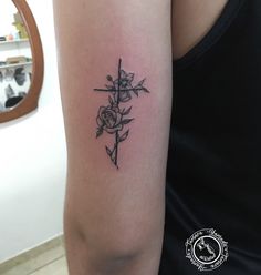 a woman with a cross and roses tattoo on her arm