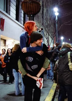 two people hugging each other on the street