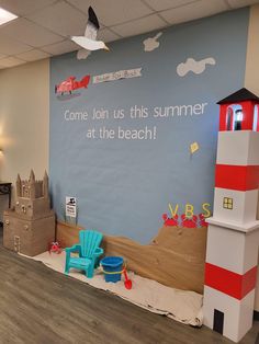 the children's playroom is decorated with cardboard boats, lighthouses and sandcastles