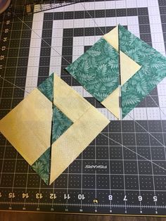 two green and yellow quilt blocks on a cutting board