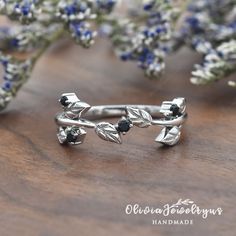 a close up of a ring on a wooden table with flowers in the back ground