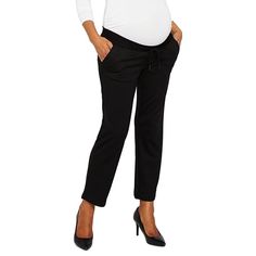 a pregnant woman standing with her hands on her hips, wearing black pants and heels