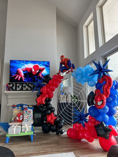 balloons are arranged in the shape of spider - man and webman on a table