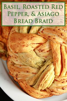 bread braided into a ball on a plate with text overlay reading basil, roasted red pepper, and asiago bread braid