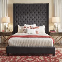 a bedroom with a bed, nightstands and two lamps on either side of the bed