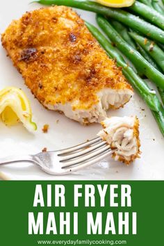 air fryer mahi mahi on a white plate with green beans and lemon wedges